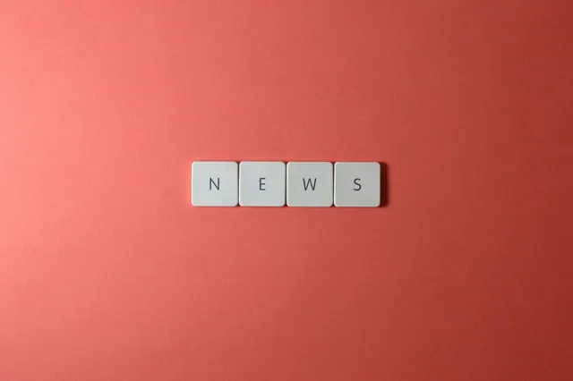 Close-up of keyboard keys spelling 'NEWS' on a red background, minimalist style.