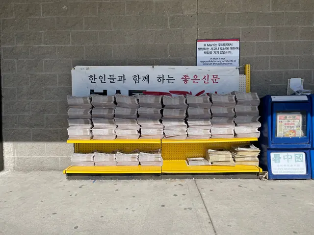 Copies of Boston Korea, a Korean-language newspaper serving New England, stacked on a free distribution rack outside H Mart in Burlington, Massachusetts. The banner above reads "A. Does a study's sample size support the headline before it runs?
