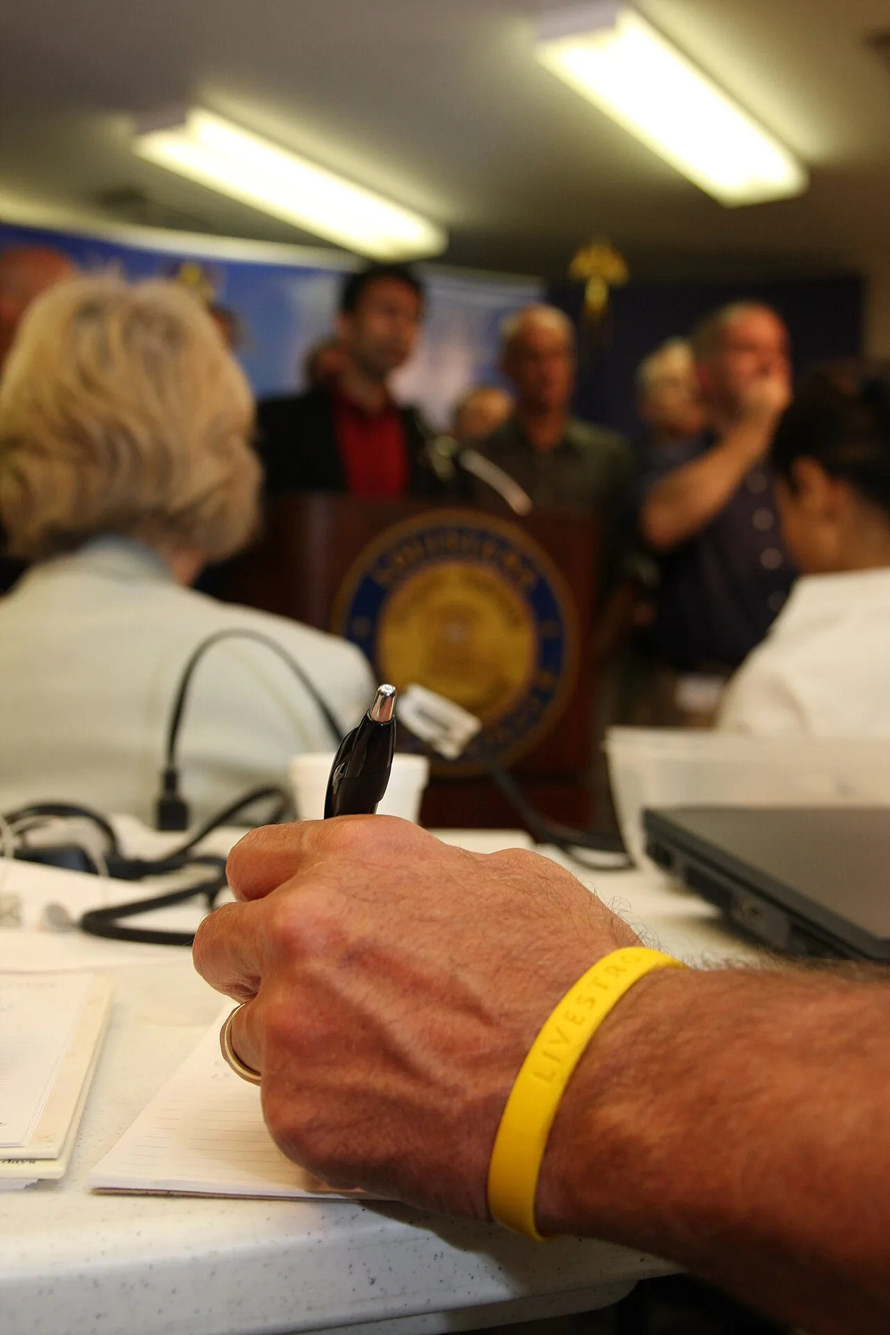 A reporter taking notes during a public press event